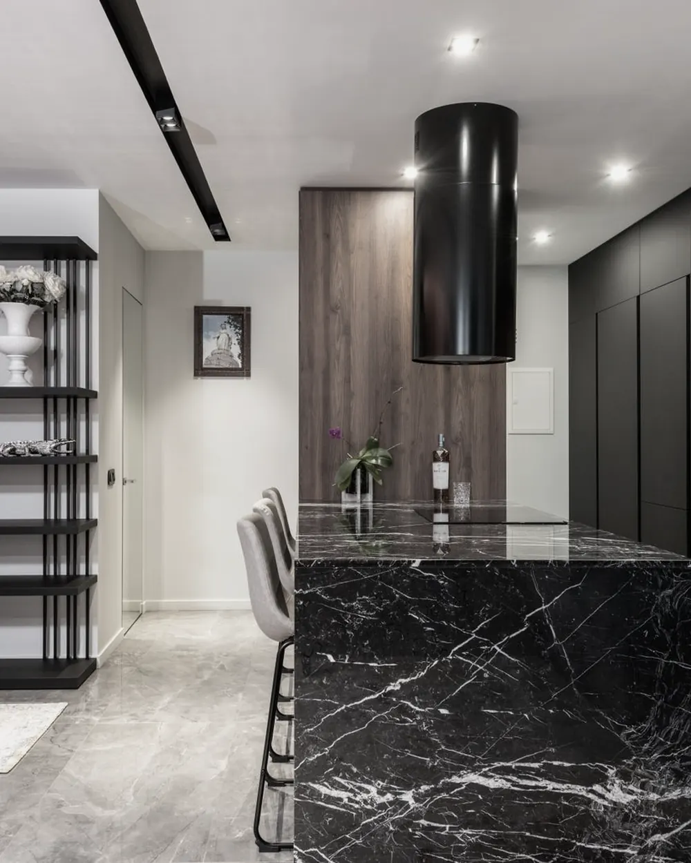 Kitchen with a black marble island with white veins and bar stools