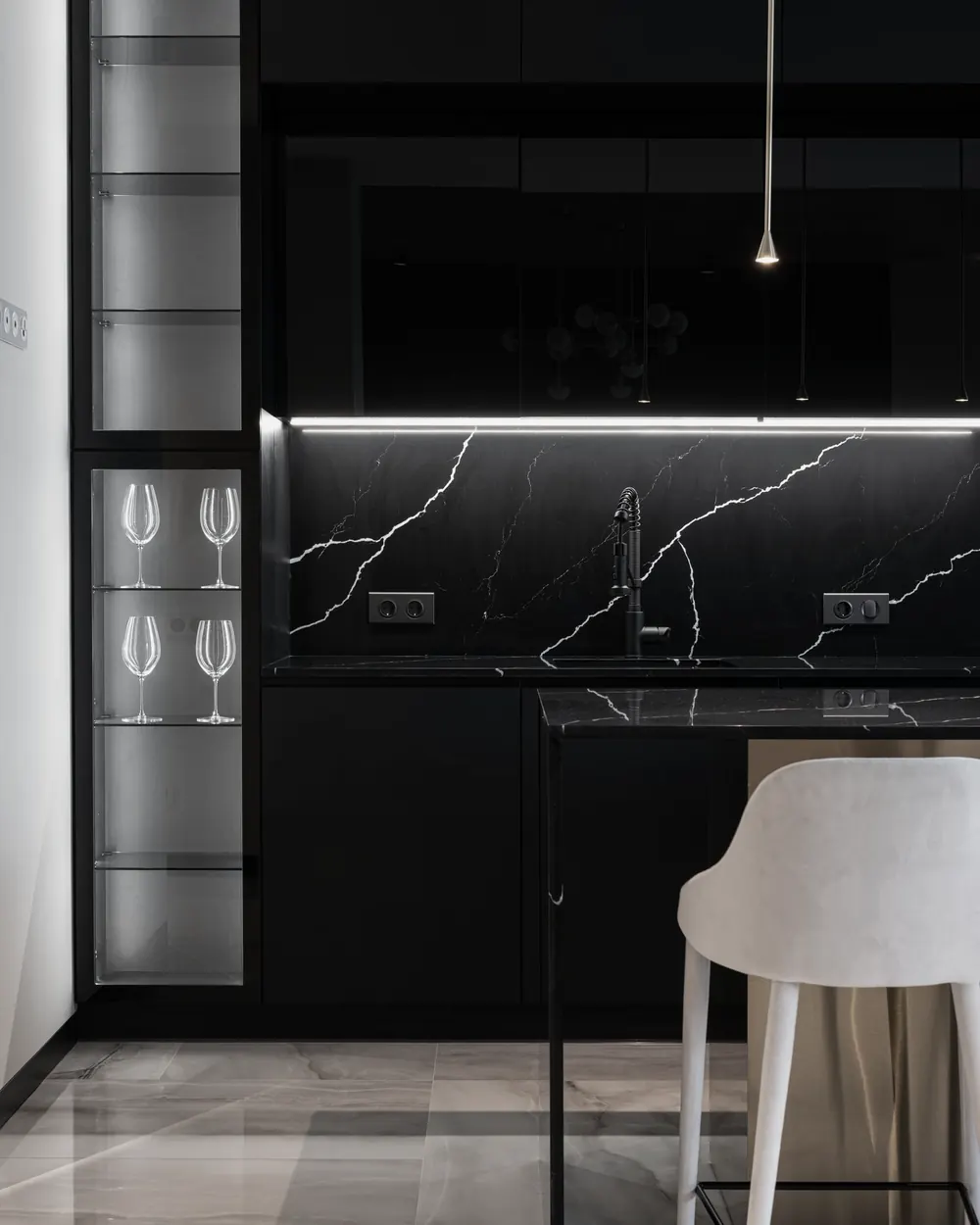 Dark kitchen with a black marble splashback and countertop with white veins